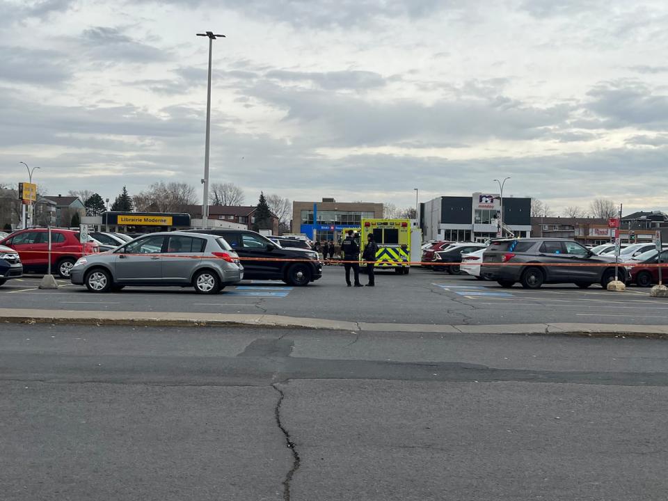 Police investigate at a commercial parking lot in Saint-Jean-sur-Richelieu on Montreal's South Shore. (Edith Parizeau/Radio-Canada - image credit)