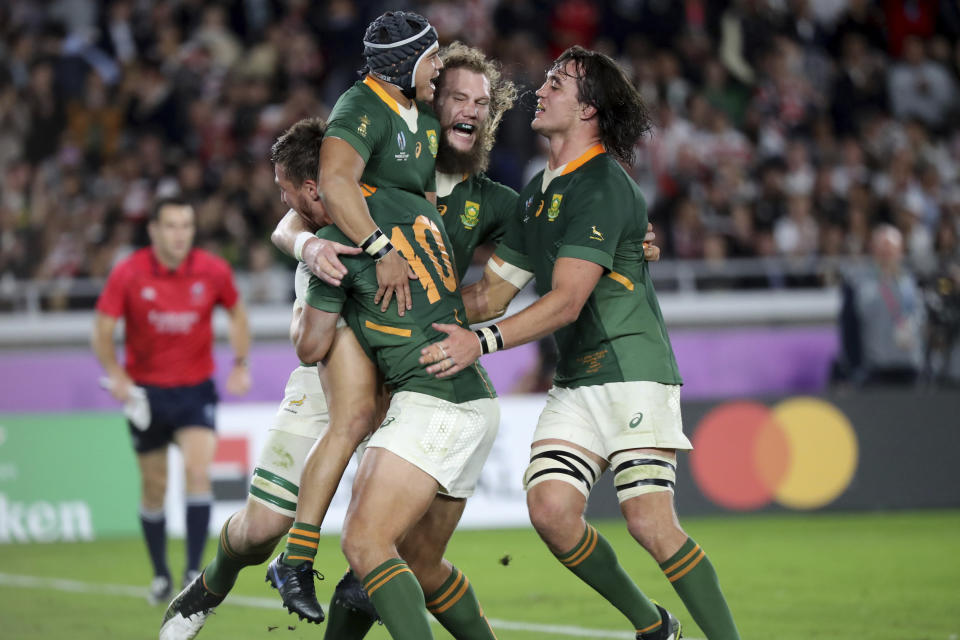 South Africa's Cheslin Kolbe, top left, celebrates with teammates after scoring a try against England during the Rugby World Cup final at International Yokohama Stadium in Yokohama, Japan, Saturday, Nov. 2, 2019. (AP Photo/Eugene Hoshiko)