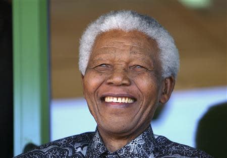 Nelson Mandela smiles as he watches the coronation ceremony of Bafokeng's King Leruo Tshekedi Molotlegi at a sports stadium in Phokeng, 120 km (81 miles) north of Johannesburg, in this August 16, 2003 file photo. REUTERS/Thomas White/Files