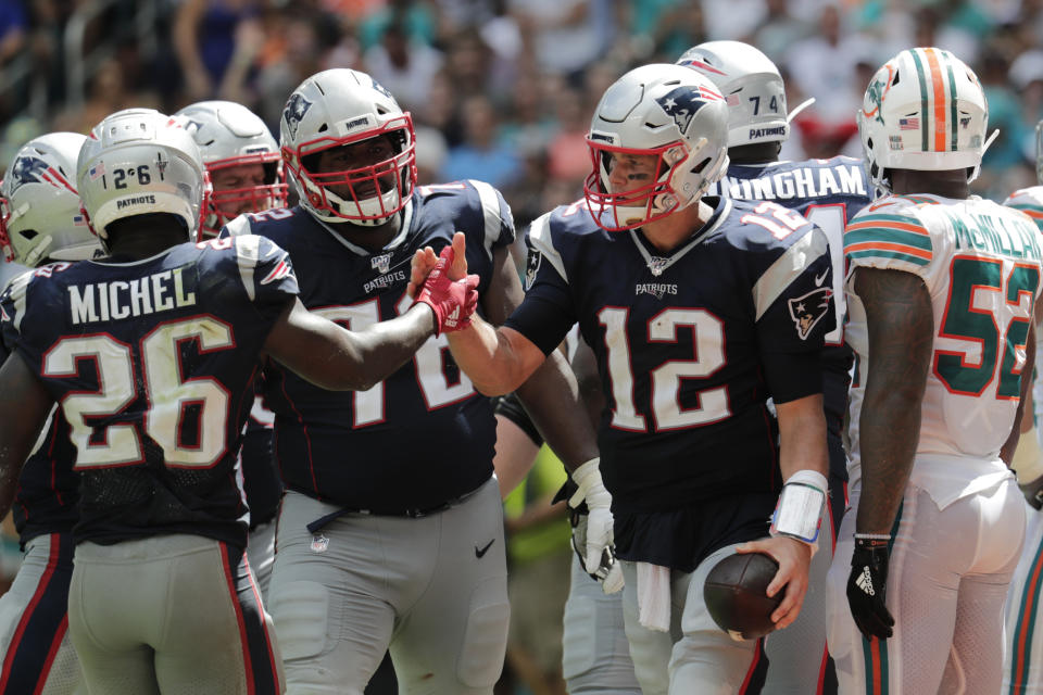 New England Patriots running back Sony Michel (26) congratulates quarterback Tom Brady (12) after Brady scored a touchdown, during the second half at an NFL football game against the Miami Dolphins, Sunday, Sept. 15, 2019, in Miami Gardens, Fla. (AP Photo/Lynne Sladky)