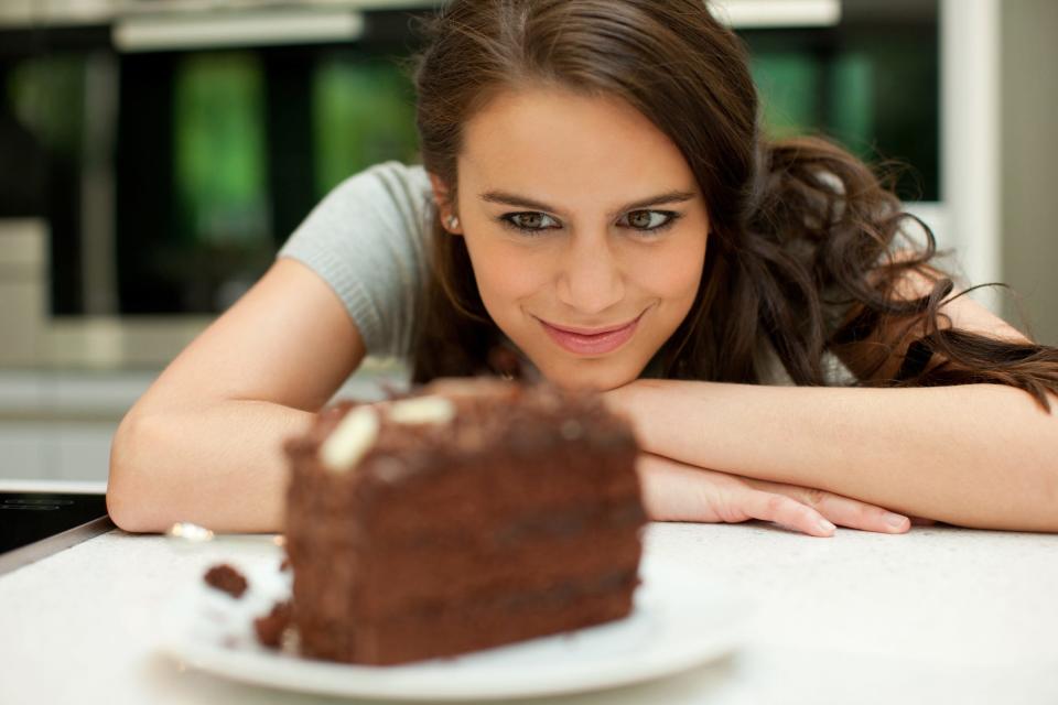 woman staring at chocolate cake