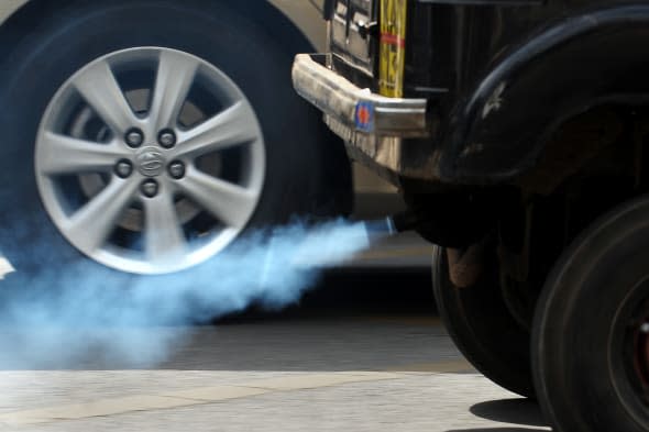 An auto-rickshaw emits exhaust fumes on