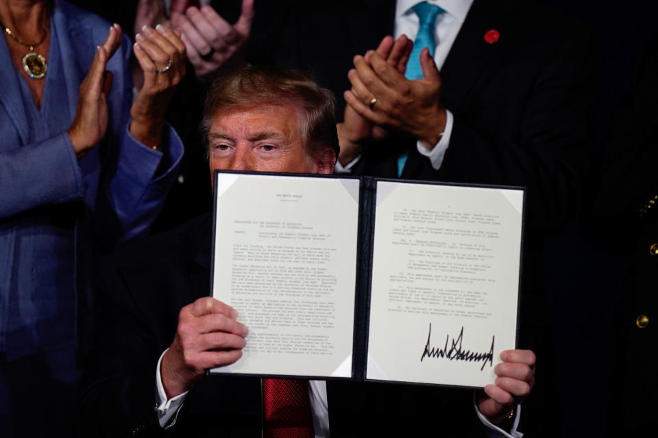 U.S. President Donald Trump holds an executive order relieving qualified disabled veterans of federally held student loan debt after speaking at the AMVETS (American Veterans) National Convention in Louisville, Kentucky. U.S., August 21, 2019.   REUTERS/Bryan Woolston