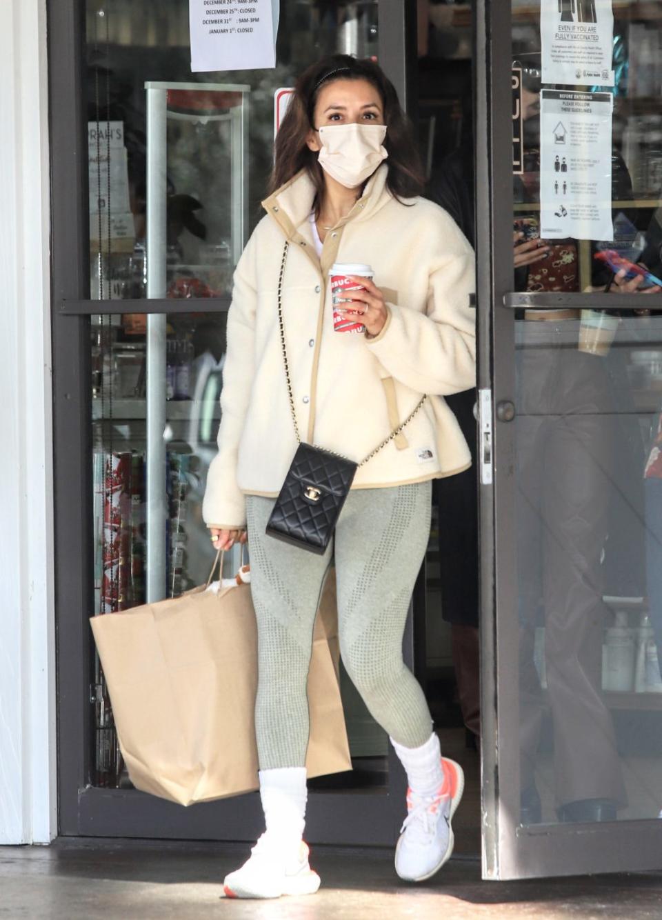 Eva Longoria runs errands in cream fleece jacket, green leggings, white Nike sneakers and Chanel crossbody bag on Dec 28, 2021. - Credit: APEX / MEGA