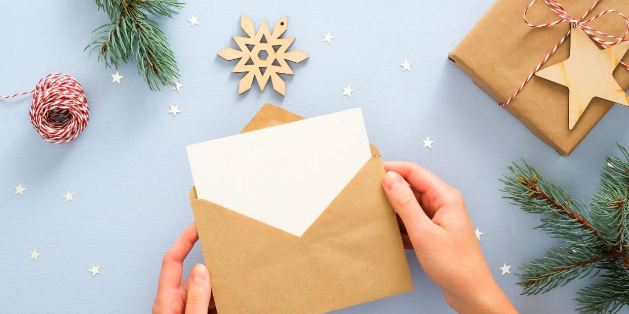 holding a card in an envelope with a blue festive background