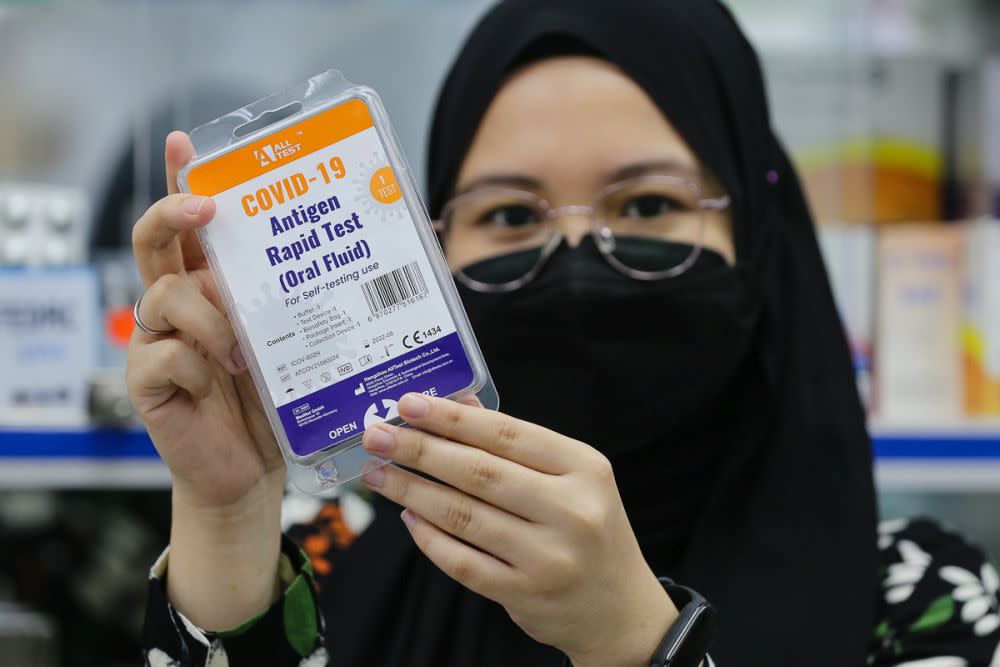 A staff holds up a Covid-19 antigen self-test kit at a pharmacy in Sri Gombak September 9, 2021. — Picture by Yusof Mat Isa