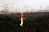 <p>Mark Clawson, 64, attempts to walk to his home on the outskirts of Pahoa during ongoing eruptions of the Kilauea Volcano in Hawaii, June 6, 2018. (Photo: Terray Sylvester/Reuters) </p>