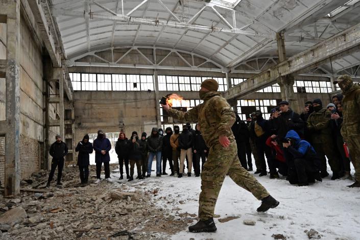 A military instructor teaches civilians to use Molotov cocktails during a training session at an abandoned factory in the Ukrainian capital of Kyiv