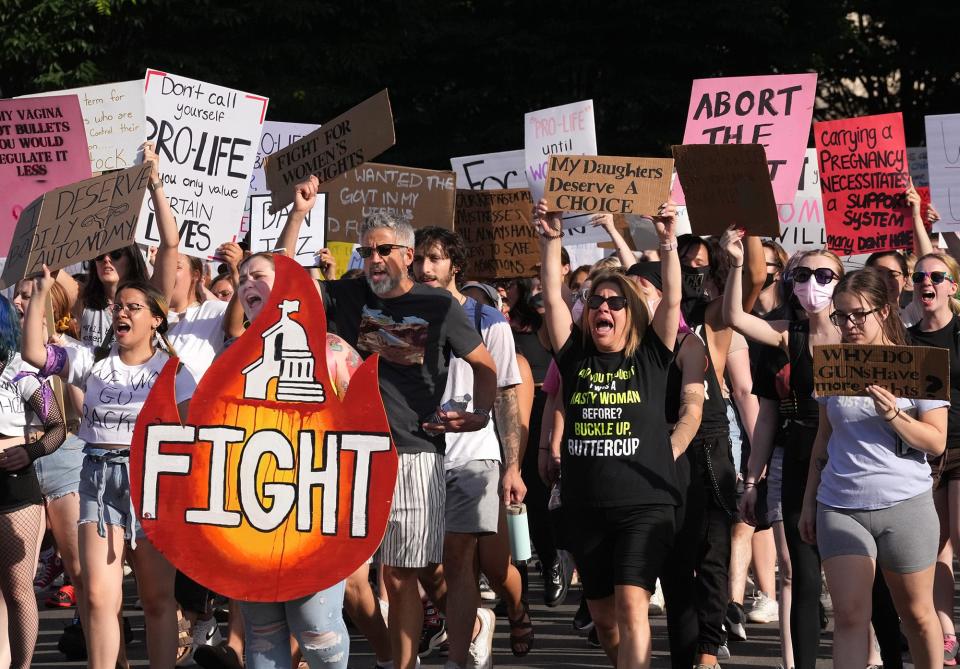 People march Downtown to the Statehouse during a central Ohio students-led rally for reproductive rights on Tuesday. See story, Page XA.