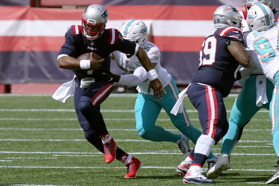 El quarterback Cam Newton de los Patriots de Nueva Inglaterra avanza con el balón frente a Kyle Van Noy (53) de los Dolphins de Miami, el domingo 13 de septiembre de 2020, en Foxborough, Massachussetts. (AP Foto/Steven Senne)