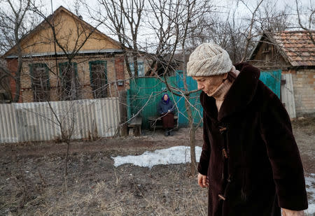 A woman sits outside her house as windows are covered with wood to protect from shrapnel near the front line in the village of Zaitseve, Ukraine, February 23, 2019. There are not many people left in Zaitseve, a village on the front line that divides Ukraine between government-controlled territory and the enclave controlled by Russian-backed separatist forces. Troops are stationed in trenches outside Zaitseve and government trucks risk rebel fire to bring bread, coal, firewood and other goods along a dirt road. REUTERS/Gleb Garanich