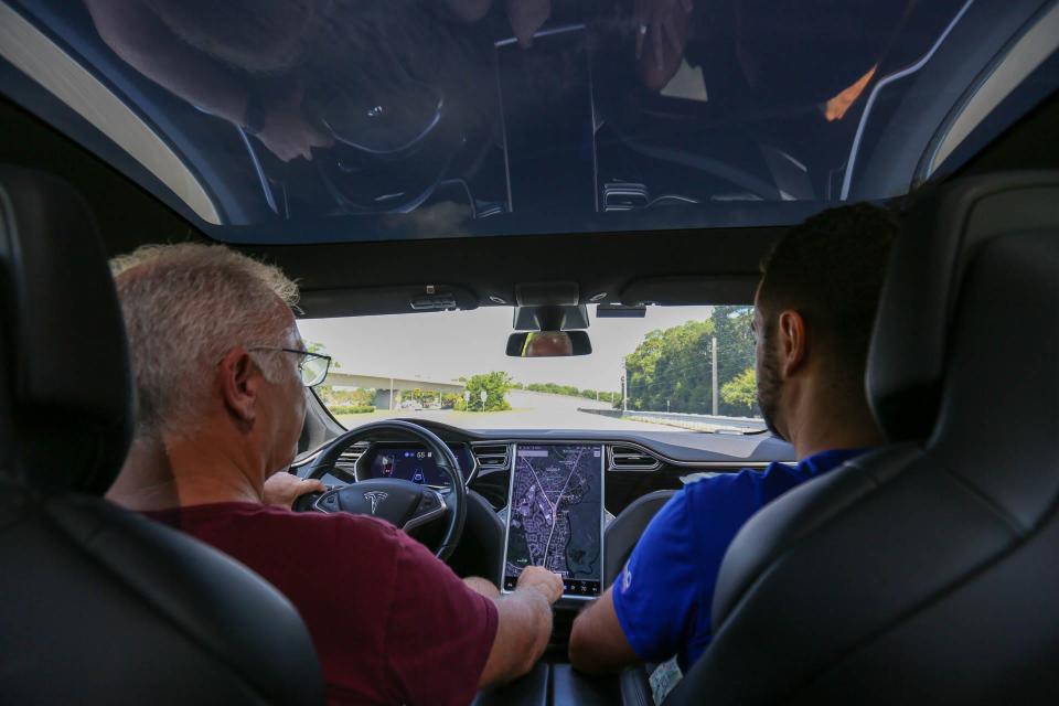 Steve Schulte and Andy Resende drive their Tesla along Highway 80 on Whitemarsh Island.
