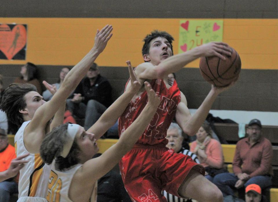 Onaway junior guard Austin Veal (24) gets ready to put up a shot while Pellston defenders look to make a block during the third quarter of Tuesday night's boys basketball contest in Pellston.