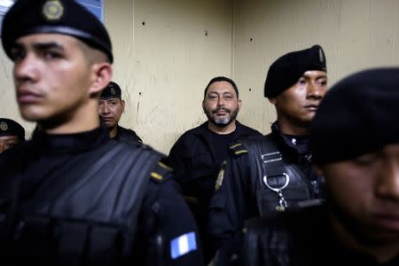 Guatemala's former Interior Minister, Mauricio Lopez Bonilla (C) is sorrounded by policemen at the basement of the Supreme Court of Justice in Guatemala City, Guatemala, June 11, 2016. REUTERS/Saul Martinez