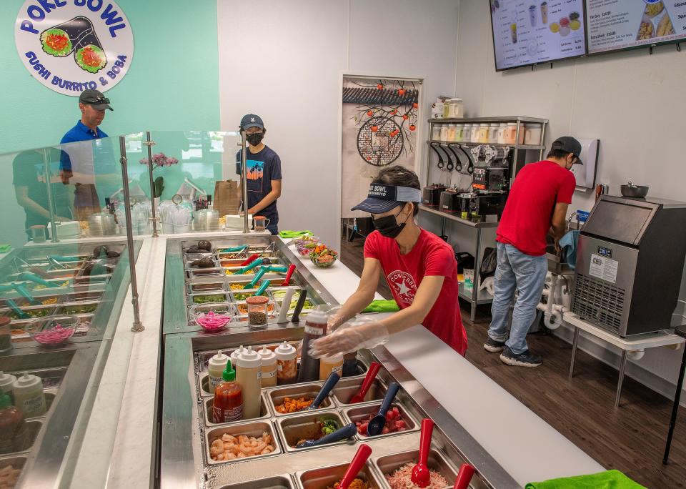 Poke Bowl manager Sopheak "Sophie" Pin prepares a rice bowl Sunday at the Gulf Breeze restaurant.