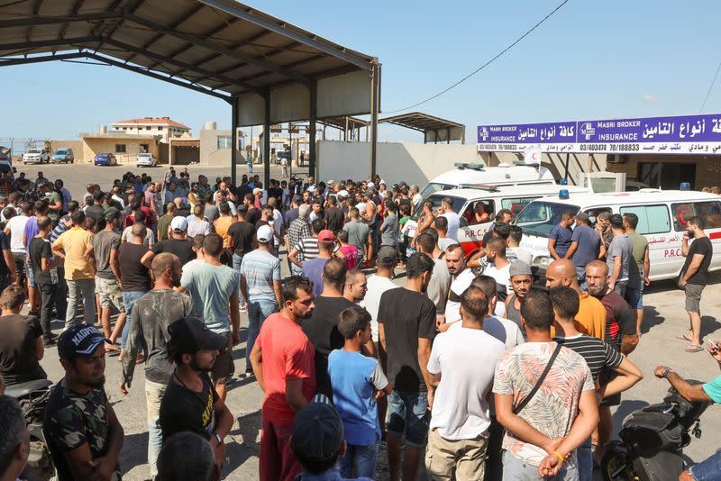 People gather following the sinking of a migrant boat