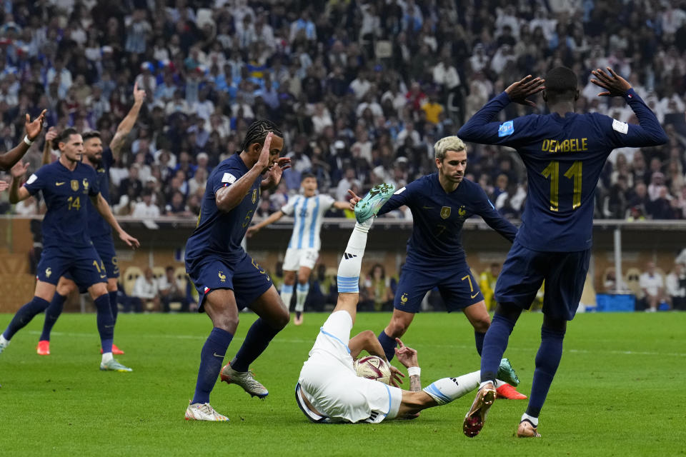 Argentina's Angel Di Maria falls in France's goal area fouled by Ousmane Dembele (11) during the World Cup final soccer match between Argentina and France at the Lusail Stadium in Lusail, Qatar, Sunday, Dec. 18, 2022. (AP Photo/Natacha Pisarenko)