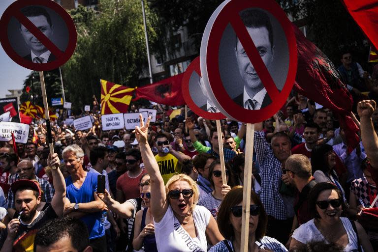 People hold signs with a picture of Macedonian Prime Minister Nikola Gruevski during an anti-government protest in downtown Skopje on May 17, 2015