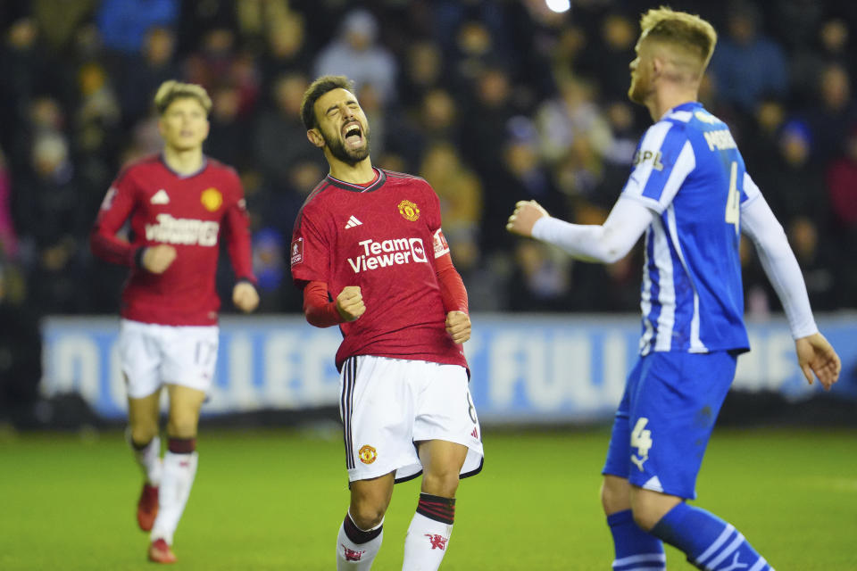 Manchester United's Bruno Fernandes, centre, celebrates after scoring his side's second goal during the English FA Cup third round soccer match between Wigan Athletic and Manchester United at the DW Stadium, Wigan, England, Monday, Jan. 8, 2024. (AP Photo/Jon Super)