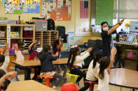 First grade teacher Suzy Tom leads a class and demonstrates the order of character strokes at the Alice Fong Yu school in San Francisco, Tuesday, Aug. 30, 2022. The school is the nation's first Chinese immersion public school and provides Cantonese instruction from kindergarten until the 8th grade. While Cantonese may be on a downward trajectory, it's not dying. Online campaigns, independent Chinese schools and Cantonese communities in and outside of Chinatowns are working to ensure future generations can carry it forward. (AP Photo/Eric Risberg)