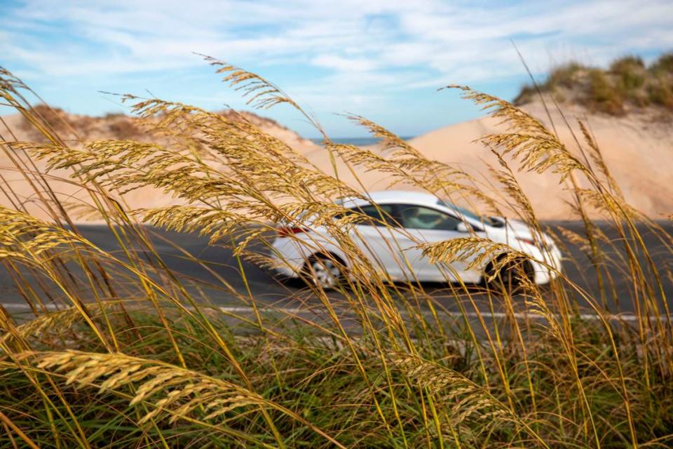 Traffic moves along NC 12 adjacent to dunes, where less than 500 feet separate the Atlantic Ocean and the Pamlico Sound, in one of the hots spots the NC 12 Task Force is studying to find solutions to erosion and flooding on Tuesday, July 13, 2021 in Hatteras, N.C.