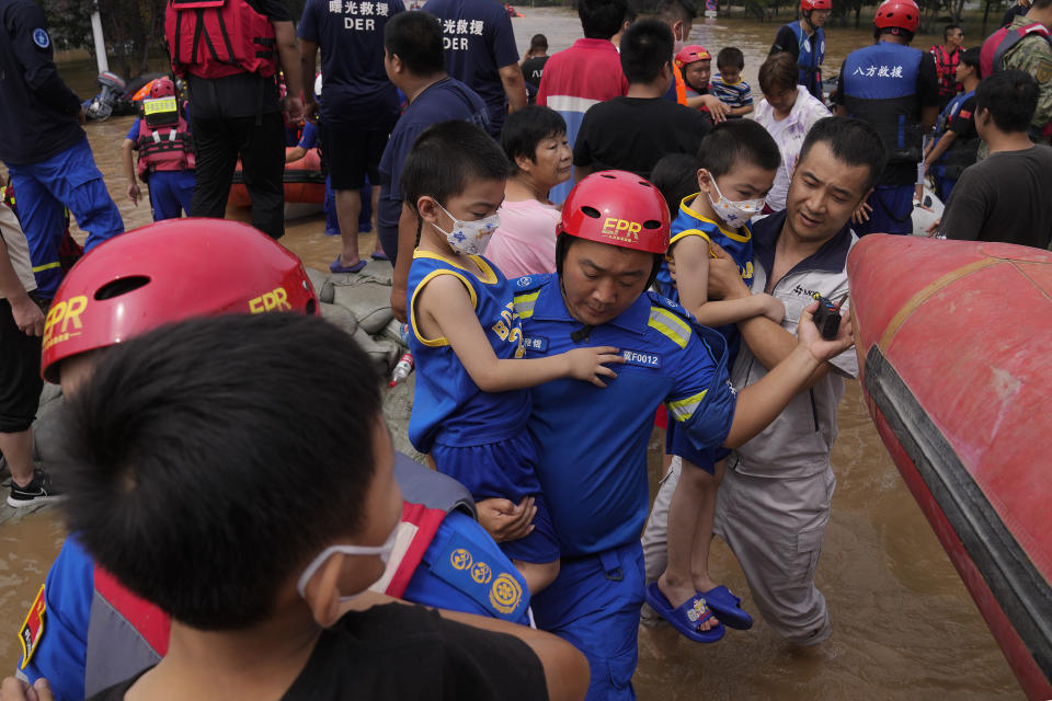 Rescuers help carry children as floods trapped residents are evacuated by rubber boats in Zhuozhou in northern China's Hebei province, south of Beijing, Wednesday, Aug. 2, 2023. China's capital has recorded its heaviest rainfall in at least 140 years over the past few days. Among the hardest hit areas is Zhuozhou, a small city that borders Beijing's southwest. (AP Photo/Andy Wong)