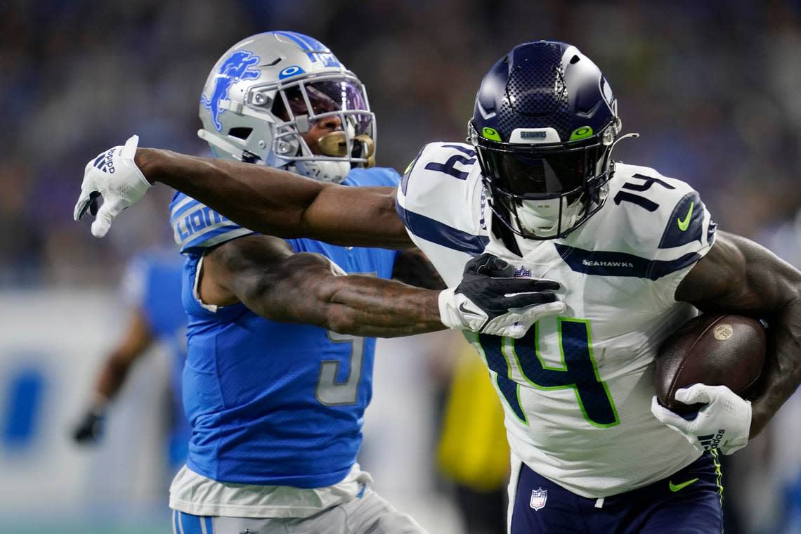 Seattle Seahawks wide receiver DK Metcalf (14) pushes Detroit Lions safety DeShon Elliott (5) during the first half of an NFL football game, Sunday, Oct. 2, 2022, in Detroit. (AP Photo/Paul Sancya)