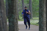 Jelani Houseworth, 41, runs along the 1-mile Parham Bridges walking track, Monday, March 23, 2020, in Jackson, Miss. Runners across the country are still hitting the pavement and the trails, staying fit and working off some stress amid the coronavirus pandemic. (AP Photo/Rogelio V. Solis)