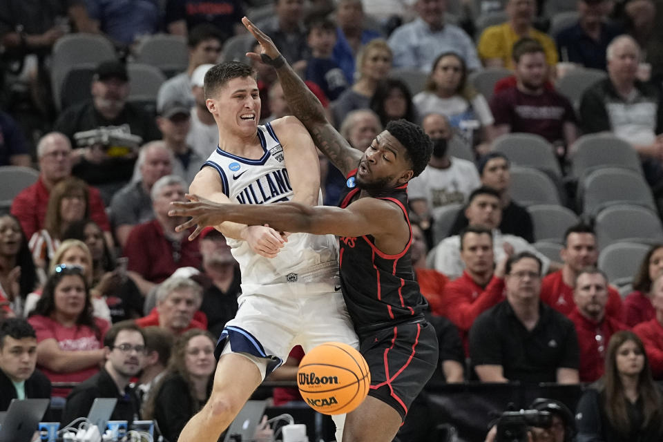 Villanova guard Collin Gillespie passes around Houston guard Jamal Shead during the first half of a college basketball game in the Elite Eight round of the NCAA tournament on Saturday, March 26, 2022, in San Antonio. (AP Photo/David J. Phillip)