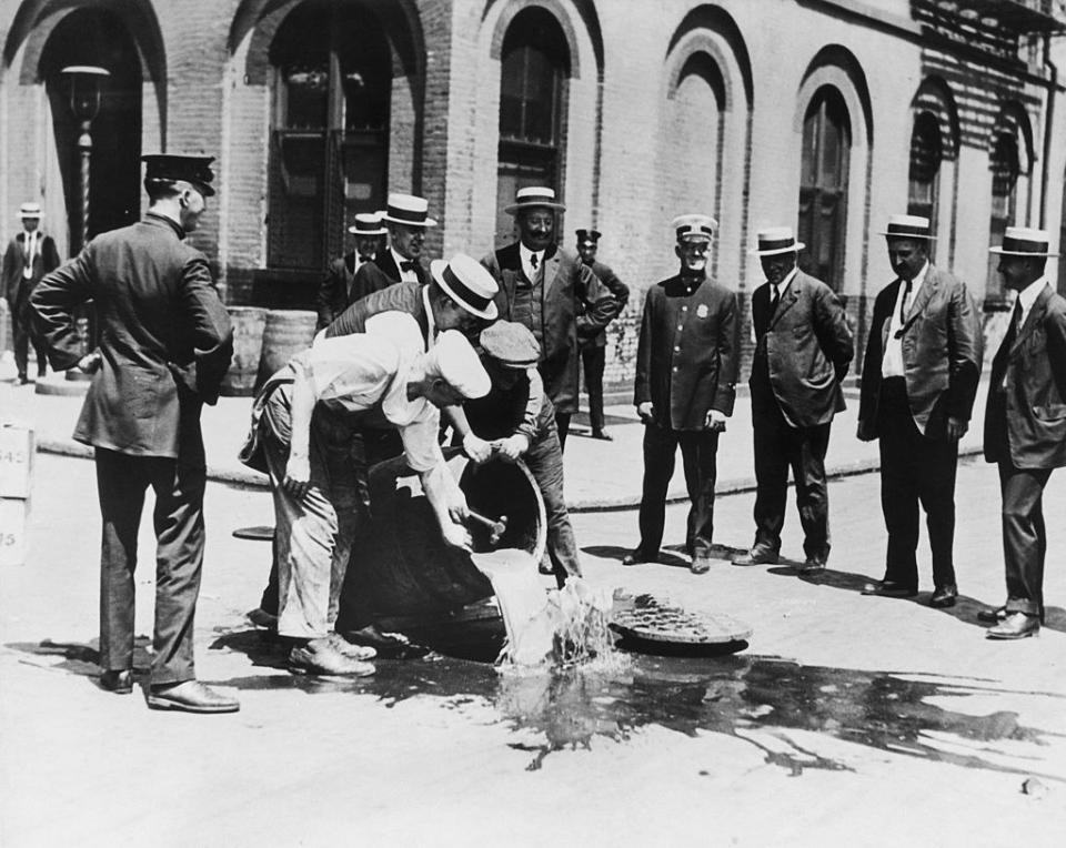 Alcohol is poured away into a New York sewer during the prohibition era, circa 1920
