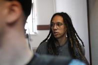 WNBA star and two-time Olympic gold medalist Brittney Griner is escorted to a courtroom for a hearing, in Khimki just outside Moscow, Russia, Monday, June 27, 2022. More than four months after she was arrested at a Moscow airport for cannabis possession, American basketball star Brittney Griner is to appear in court Monday for a preliminary hearing ahead of her trial. (AP Photo/Alexander Zemlianichenko)