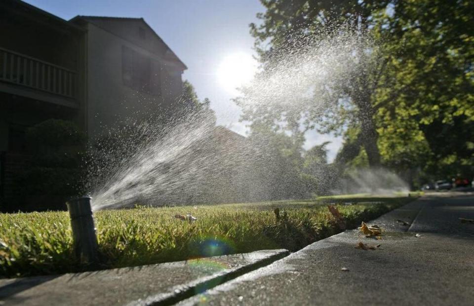 Sprinklers water grass at a home on July 1, 2014.