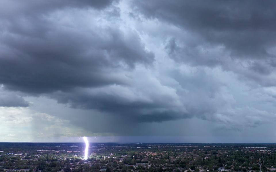 Lightning strikes the ground as an afternoon thunderstorm rolls into Greenacres, Florida, on June 25, 2024.