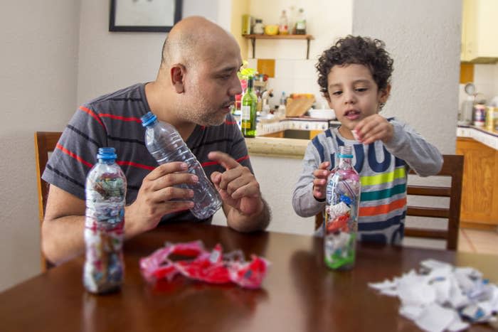 a dad making eco bricks with his son