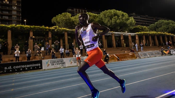 A man in orange shorts runs in the evening