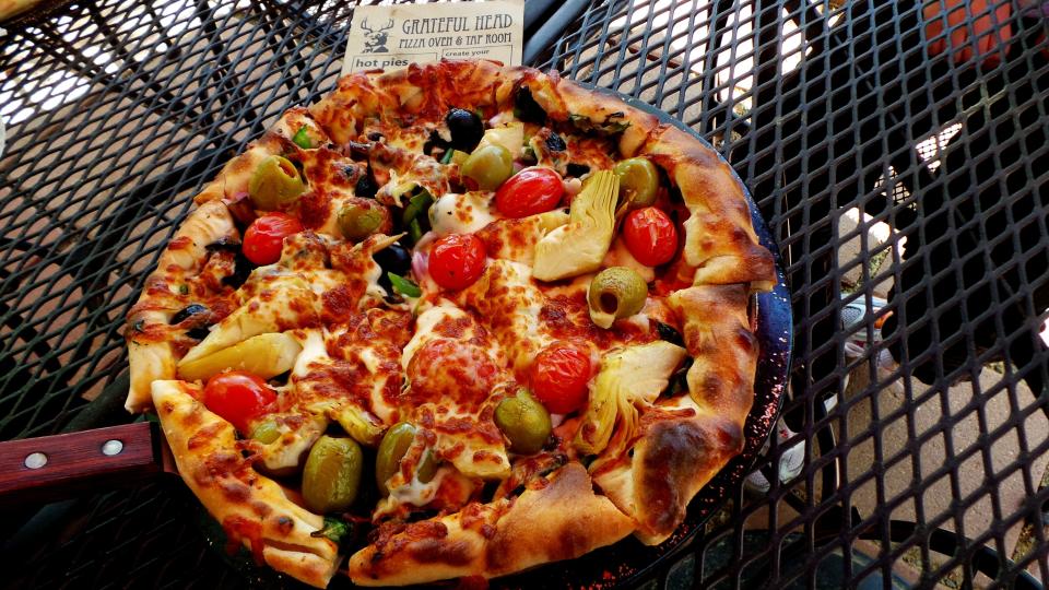 The Grateful Head Pizza Oven and Taproom offer thick, homemade brick-oven pizza, like this "Tree Hugger" topped with artichoke hearts, capers, olives, roasted garlic and more.