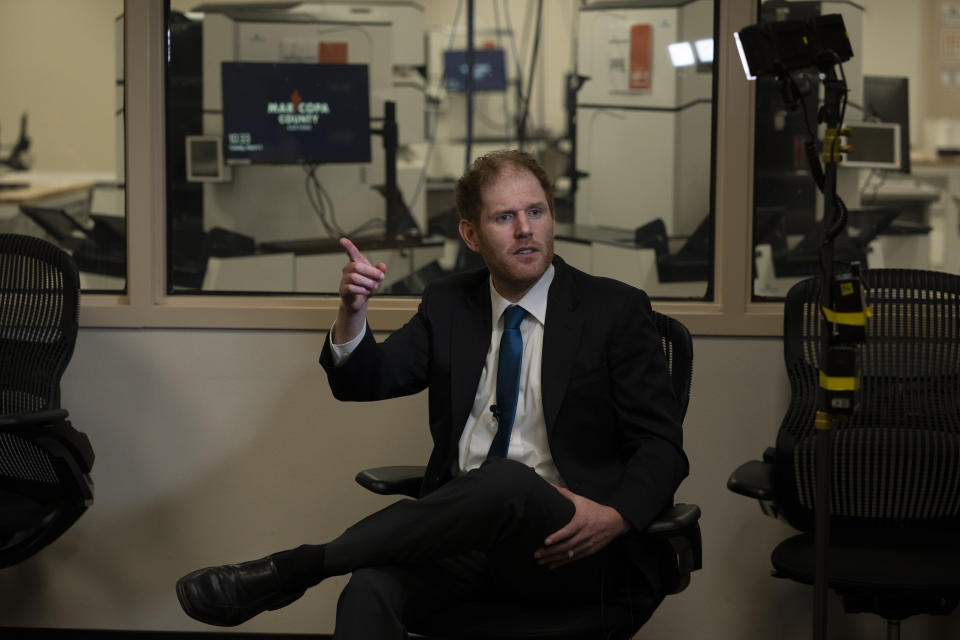 Maricopa County Recorder Stephen Richer, a Republican, gestures during an interview with the Associated Press in Phoenix, Tuesday, March 5, 2024. In the background, the Maricopa County tabulation room is seen through windows. (AP Photo/Serkan Gurbuz)