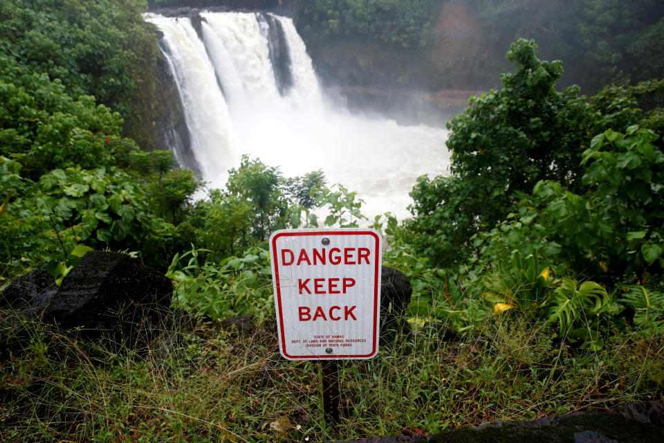 A sign warns of danger at a waterfall swollen by rain from Hurricane Lane in Hilo, Hawaii, U.S., August 25, 2018.  REUTERS/Terray Sylvester