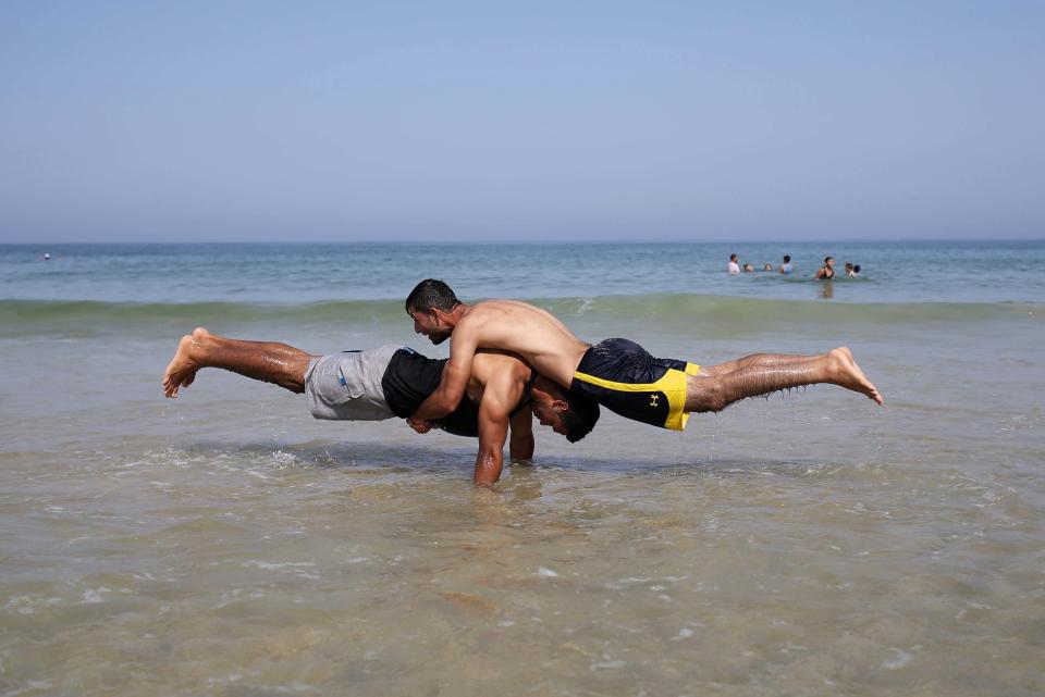 Members of Palestinian sports group Bar Palestine perform on the beach in Gaza City on August 7, 2015. Street workout, which is still new in Gaza, is a growing sport across the world with annual competitions and events. 