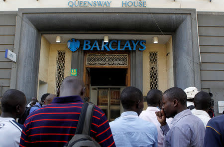 Civilians gather at the entrance of the banking hall after Kenyan police seized fake currency in a personal safety deposit box at the Queensway branch of Barclays Bank of Kenya, in downtown Nairobi, Kenya March 19, 2019. REUTERS/Njeri Mwangi