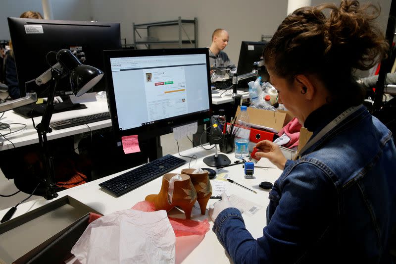 FILE PHOTO: An employee of "Vestiaire Collective", an online marketplace to buy and sell pre-owned designer clothing and accessories, checks shoes in Tourcoing