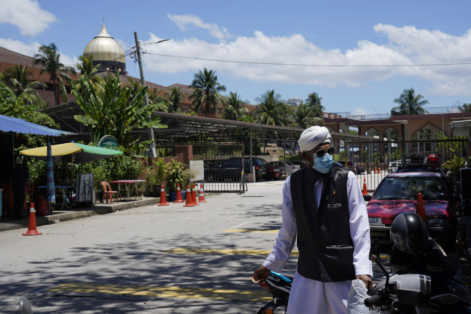 A man wears a face masks as he walks out from the Sri Petaling Mosque in Kuala Lumpur, Malaysia, on Monday, March 16, 2020. For most people, the new coronavirus causes only mild or moderate symptoms. For some it can cause more severe illness. (AP Photo/Vincent Thian)