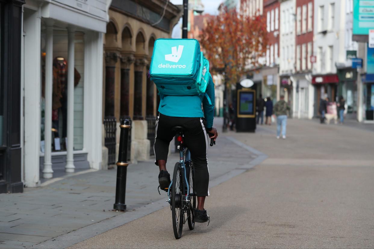 Deliveroo rider cycles along Worcester High Street (PA)