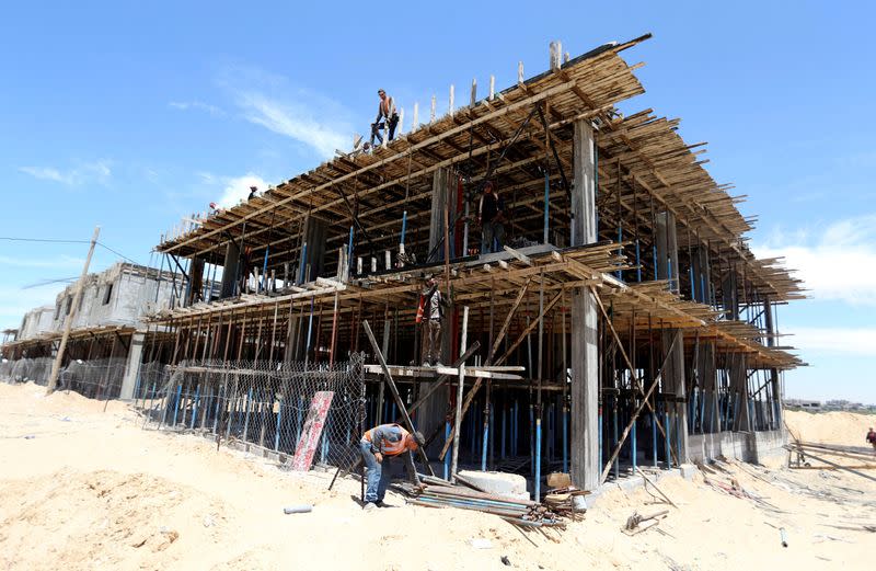 FILE PHOTO: Palestinian workers work in a Qatari-funded construction project in the southern Gaza Strip