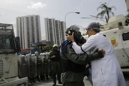 A doctor talks with a member of the Venezuelan National Guard during riots while rallying against Venezuela's President Nicolas Maduro in Caracas, Venezuela May 22, 2017. REUTERS/Carlos Barria