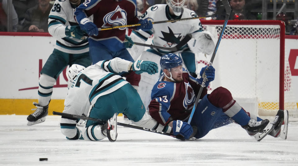 San Jose Sharks center Nico Sturm, left, falls on the ice after checking Colorado Avalanche right wing Valeri Nichushkin in the second period of an NHL hockey game Tuesday, March 7, 2023, in Denver. (AP Photo/David Zalubowski)