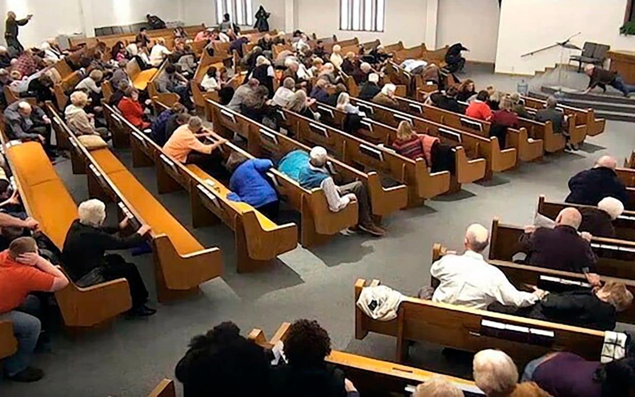 In this still frame from livestreamed video provided by law enforcement, churchgoers take cover while a congregant armed with a handgun, top left, engages a man who opened fire, near top center just right of windows, during a service at West Freeway Church of Christ, Sunday, Dec. 29, 2019, in White Settlement, Texas.  - Law Enforcement via West Freeway Church of Christ