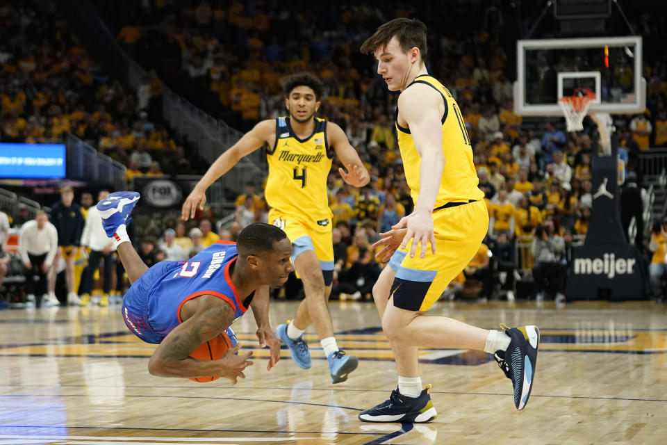 DePaul's Umoja Gibson (2) trips in front of Marquette's Tyler Kolek, right, and Stevie Mitchell (4) during the second half of an NCAA college basketball game Saturday, Feb. 25, 2023, in Milwaukee. (AP Photo/Aaron Gash)