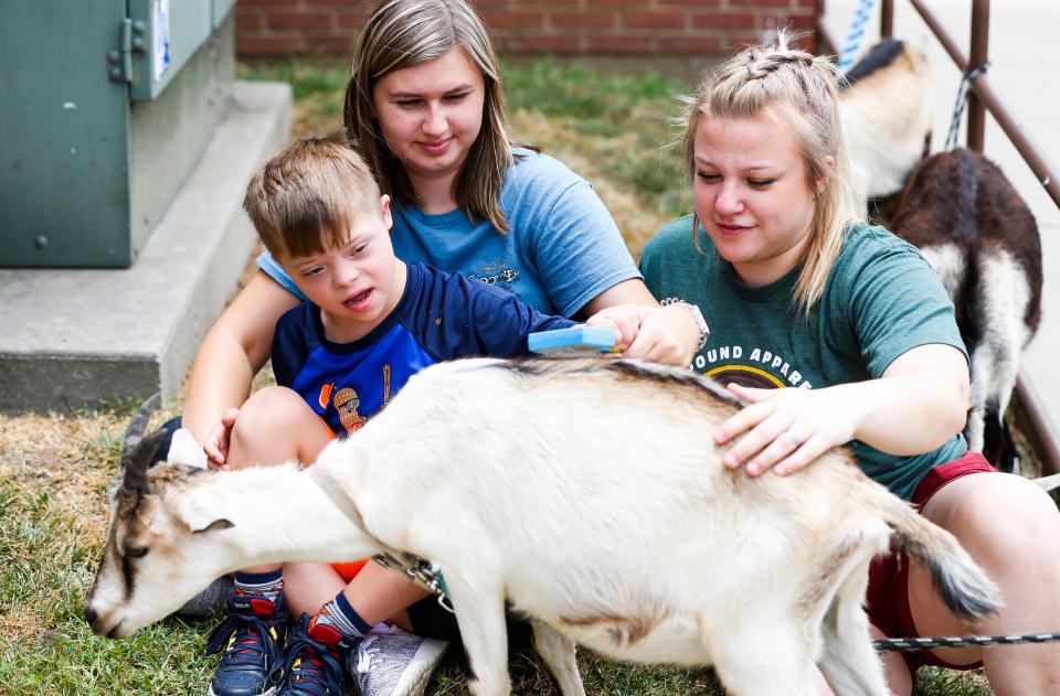 Arc of the Ozarks summer camper Estes Daniels, 6, brushes a goat from Rafter C Rodeo Goats with Arc staff members Hope Moore (middle) and Michaela Brown during an activity day at the Timothy Grant Newport Activity Center on Thursday, July 28, 2022.