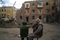FILE - Raisa Smielkova, 75, looks up as she sits in front of the site were firefighters work to extinguish a fire as they look for potential victims after a Russian attack that heavily damaged a residential building in Sloviansk, Ukraine, on Sept. 7, 2022. Smielkova was sleeping at the time of the explosion. "You would be a fool not to be scared by this," she says. "If someone asks, I say yes, I am scared." (AP Photo/Leo Correa, File)